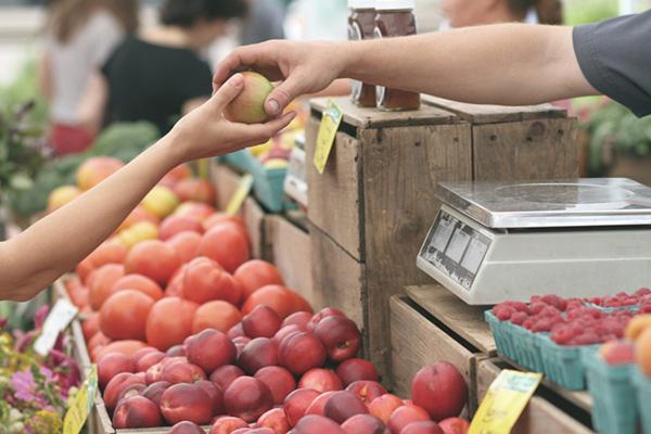 Customer purchasing produce at a farmers market.