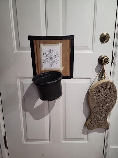 A homemade basketball hoop hanging on a door.