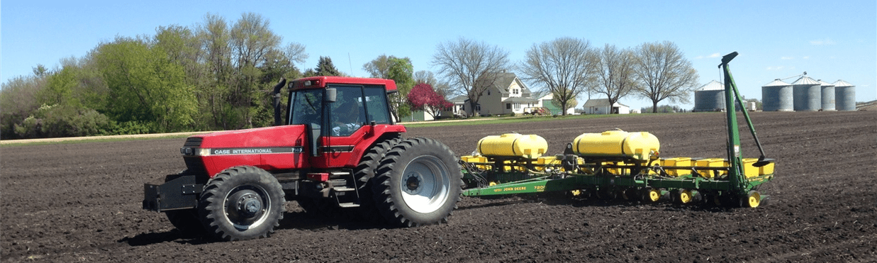 Tractor planing corn in a field.