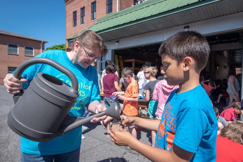 A student learning to plant with Master Gardeners